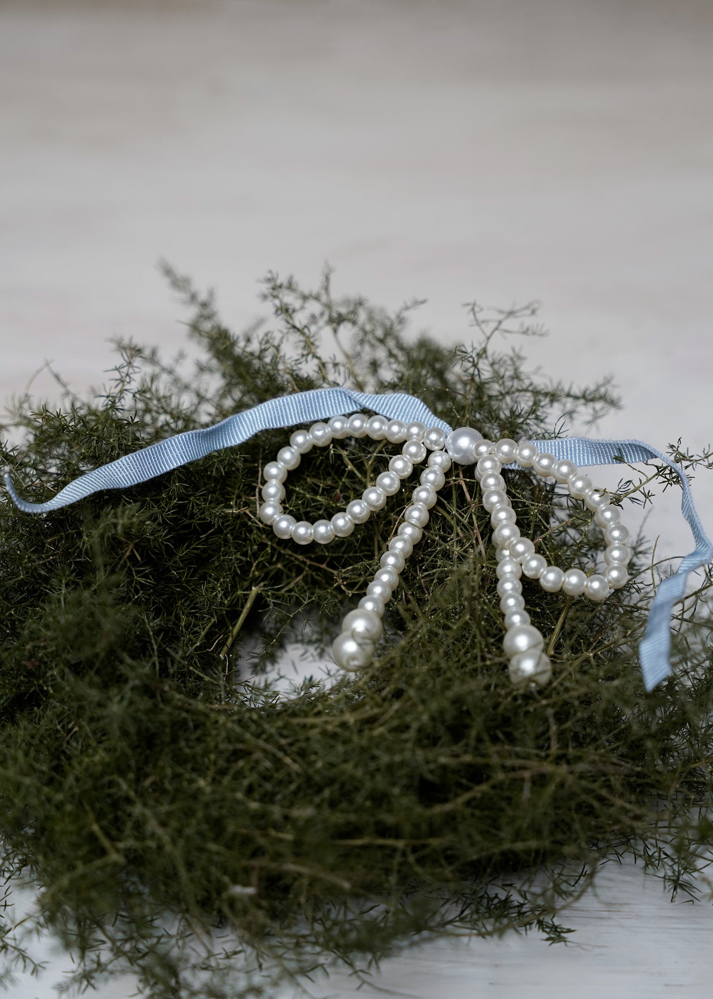 Pearl-bow with blue ribbon